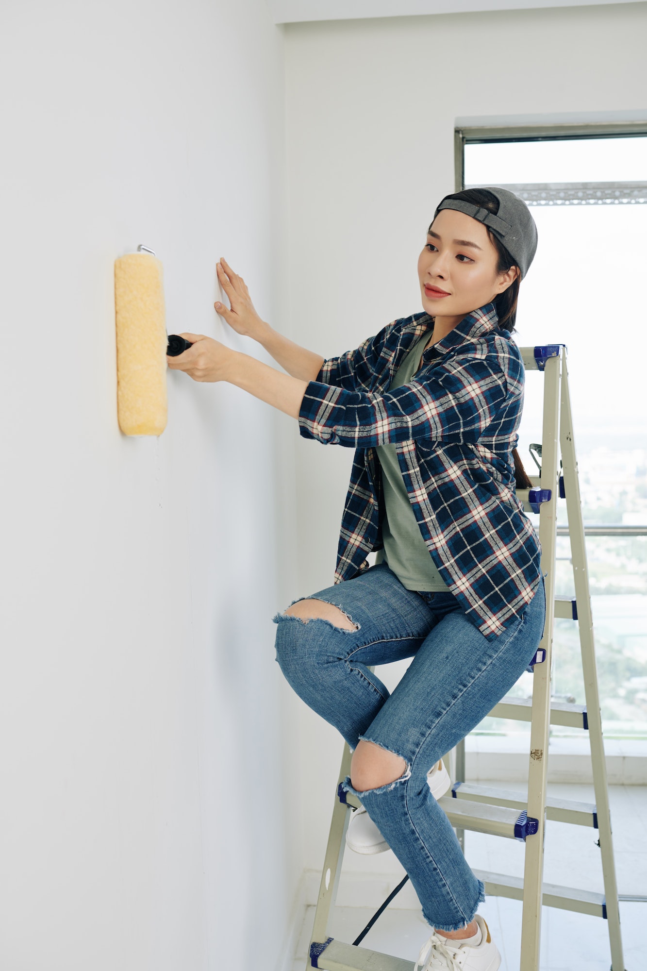 Woman painting house wall